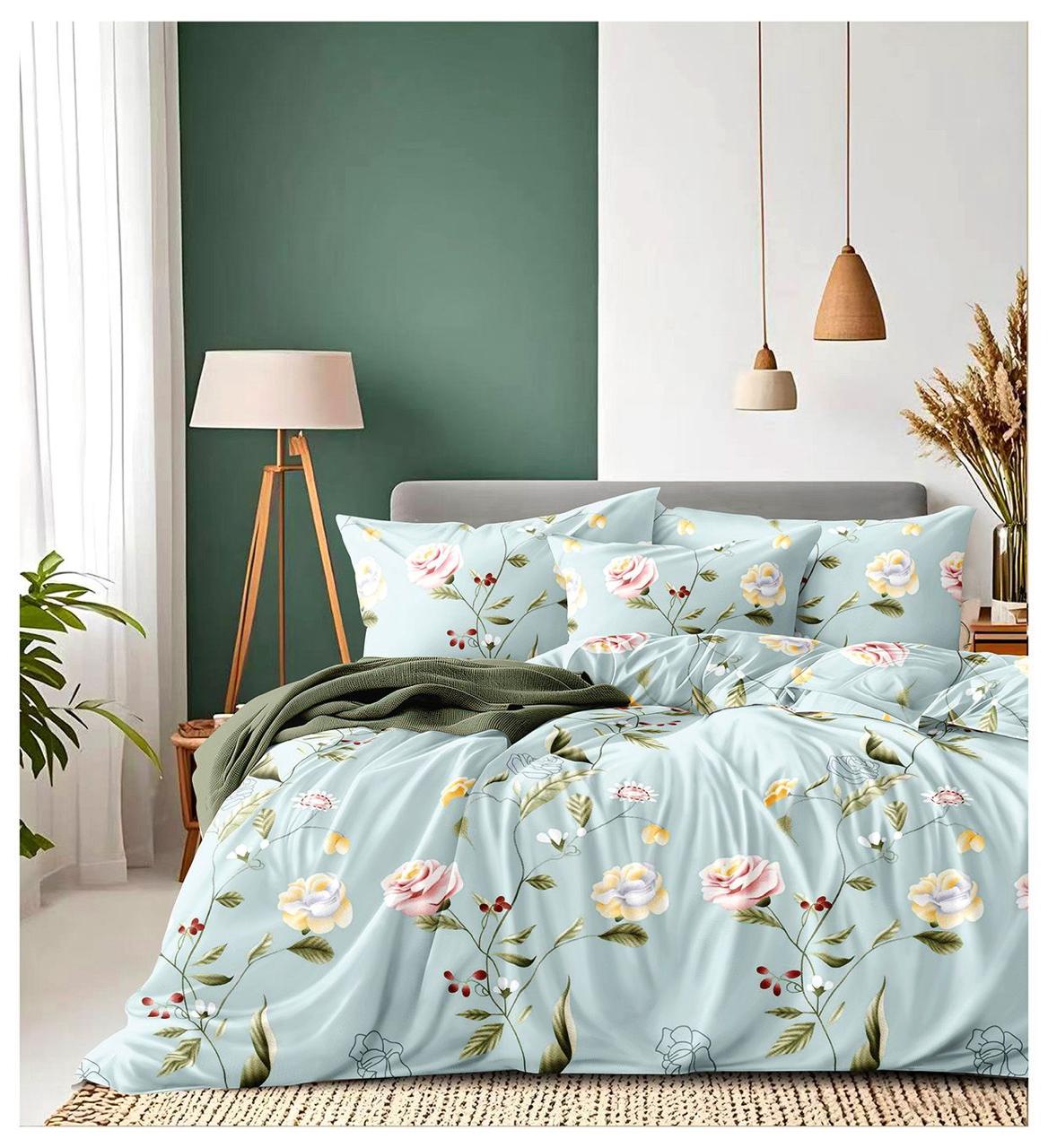 Floral bedding set on a bed in a bedroom with a green wall and lamp.