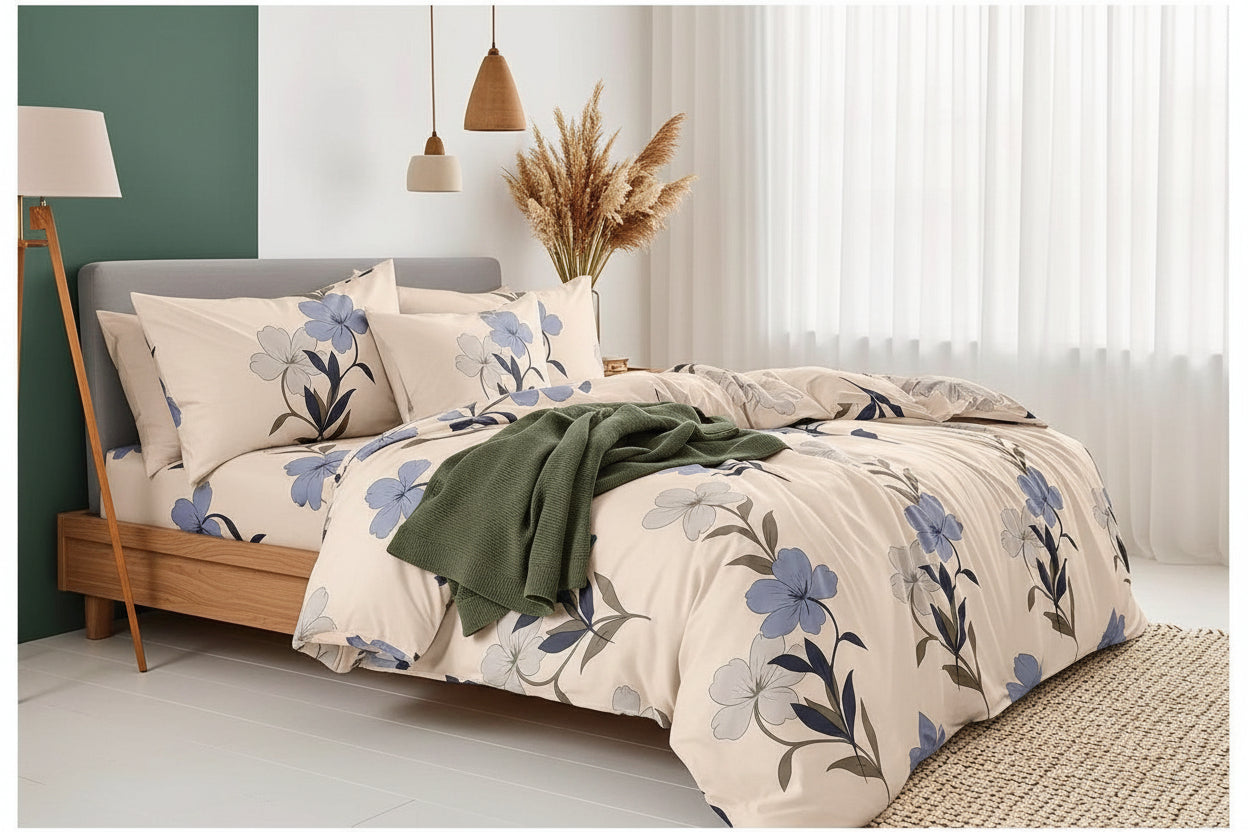 Floral bedding set on a bed in a bedroom with green wall and lamp.